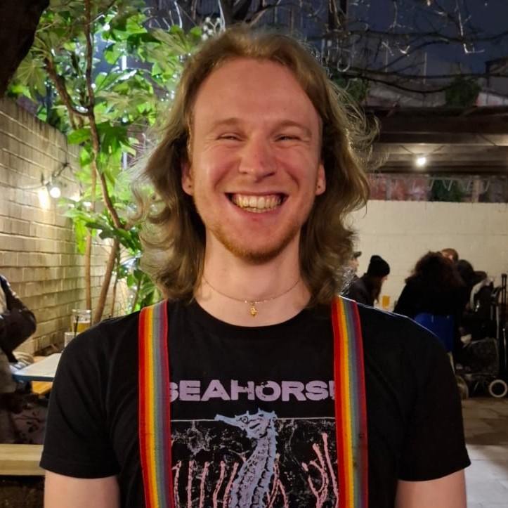 Person with long hair and suspenders.
