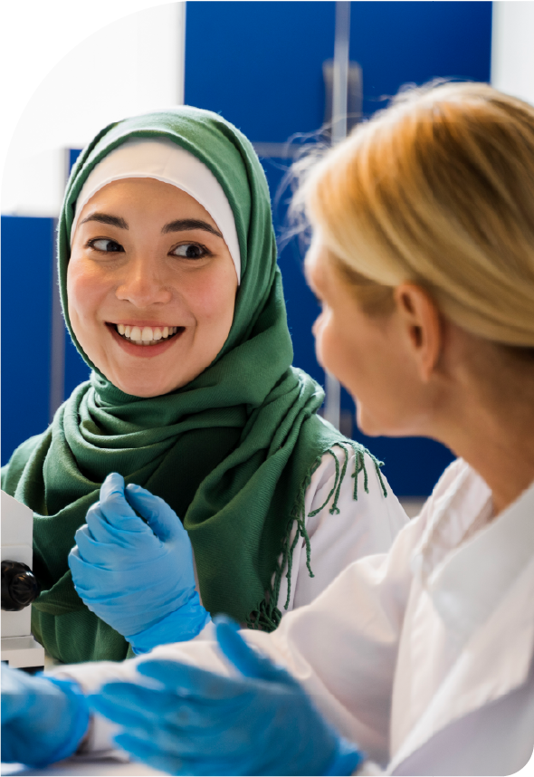Two women discussing in laboratory setting.