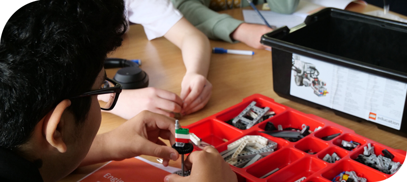 Child building with LEGO pieces.