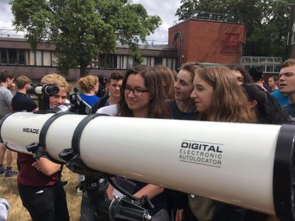 Group observing through a telescope.